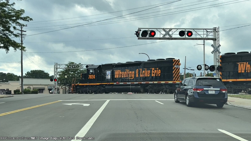 WE 7024 crosses W. Market St. with an empty hopper train.